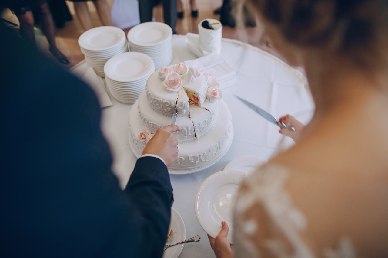 the bride and groom cut the wedding cake